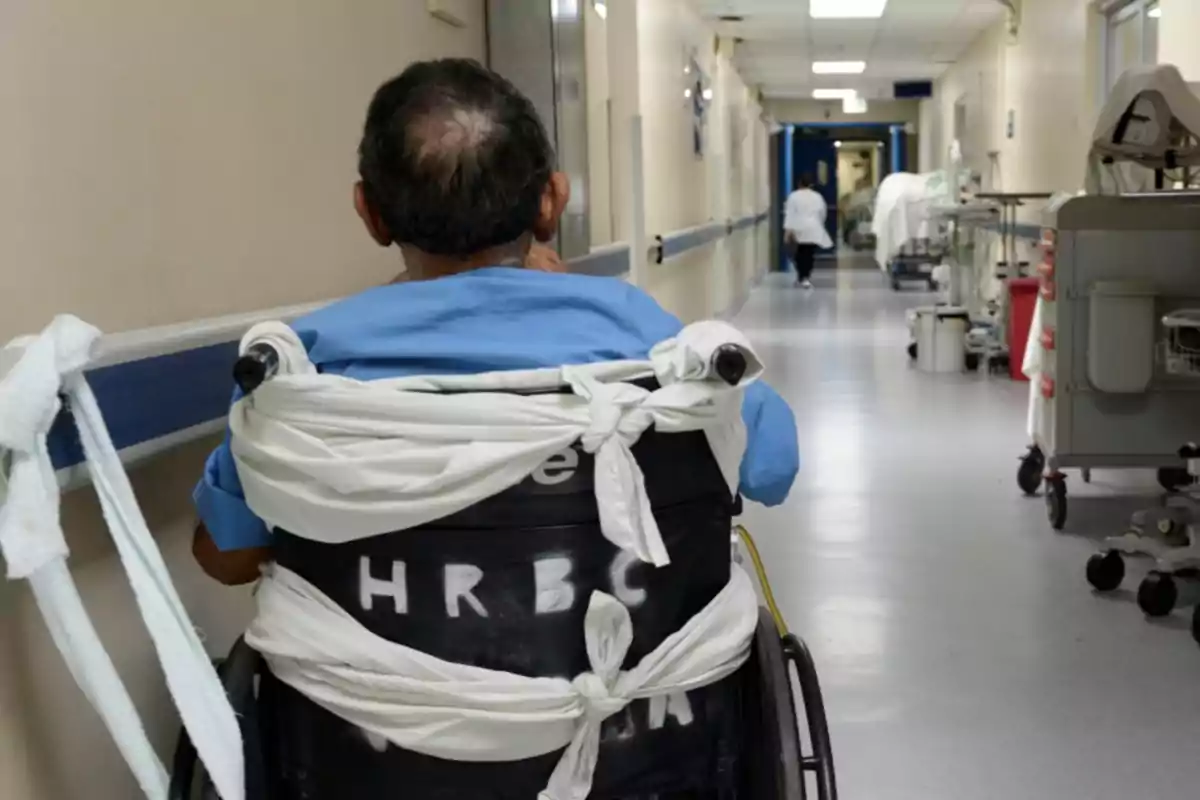 Un hombre en silla de ruedas atado con sábanas en un pasillo de hospital. Un hombre en silla de ruedas atado con sábanas en un pasillo de hospital.