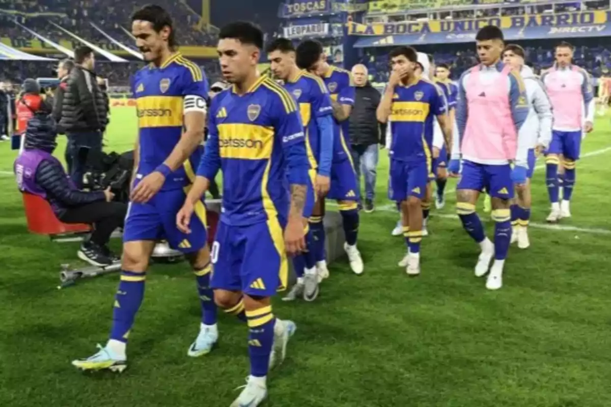 Jugadores de fútbol con uniforme azul y amarillo caminando en un estadio. Jugadores de fútbol con uniforme azul y amarillo caminando en un estadio.