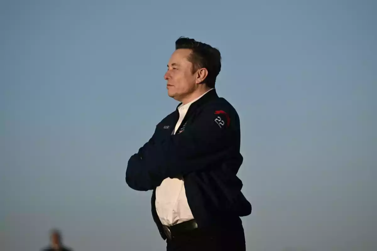 A man standing with his arms crossed looking toward the horizon on a clear day. A man standing with his arms crossed looking toward the horizon on a clear day.