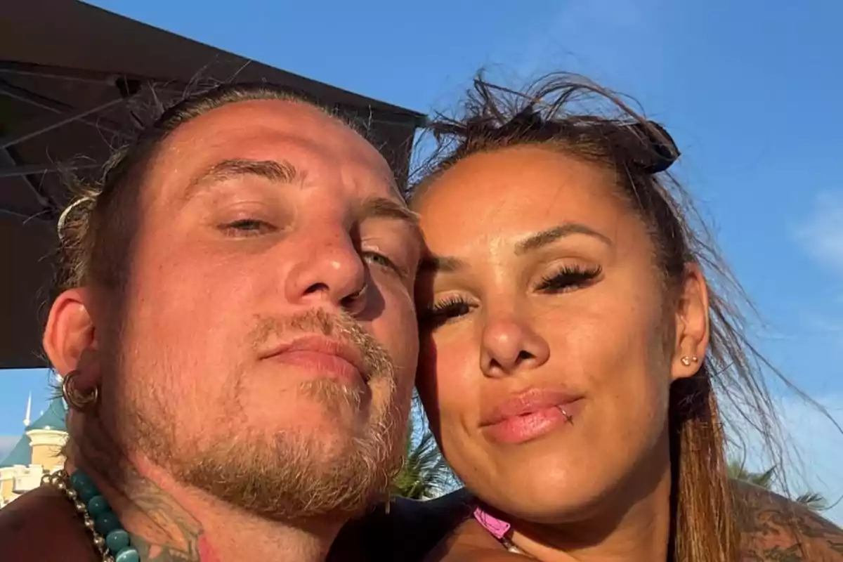 Pareja tomándose una selfie al aire libre con cielo azul de fondo Pareja tomándose una selfie al aire libre con cielo azul de fondo
