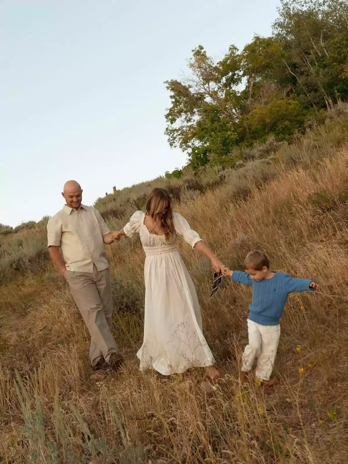 Familia caminando por un campo de hierba seca en un día soleado. Familia caminando por un campo de hierba seca en un día soleado.