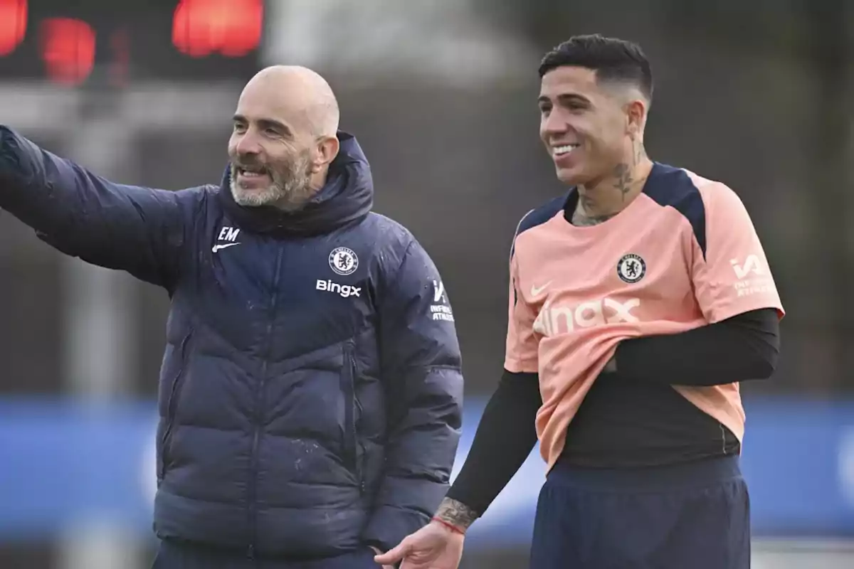 Chelsea coach and player smile and talk during a training session on the field. Chelsea coach and player smile and talk during a training session on the field.