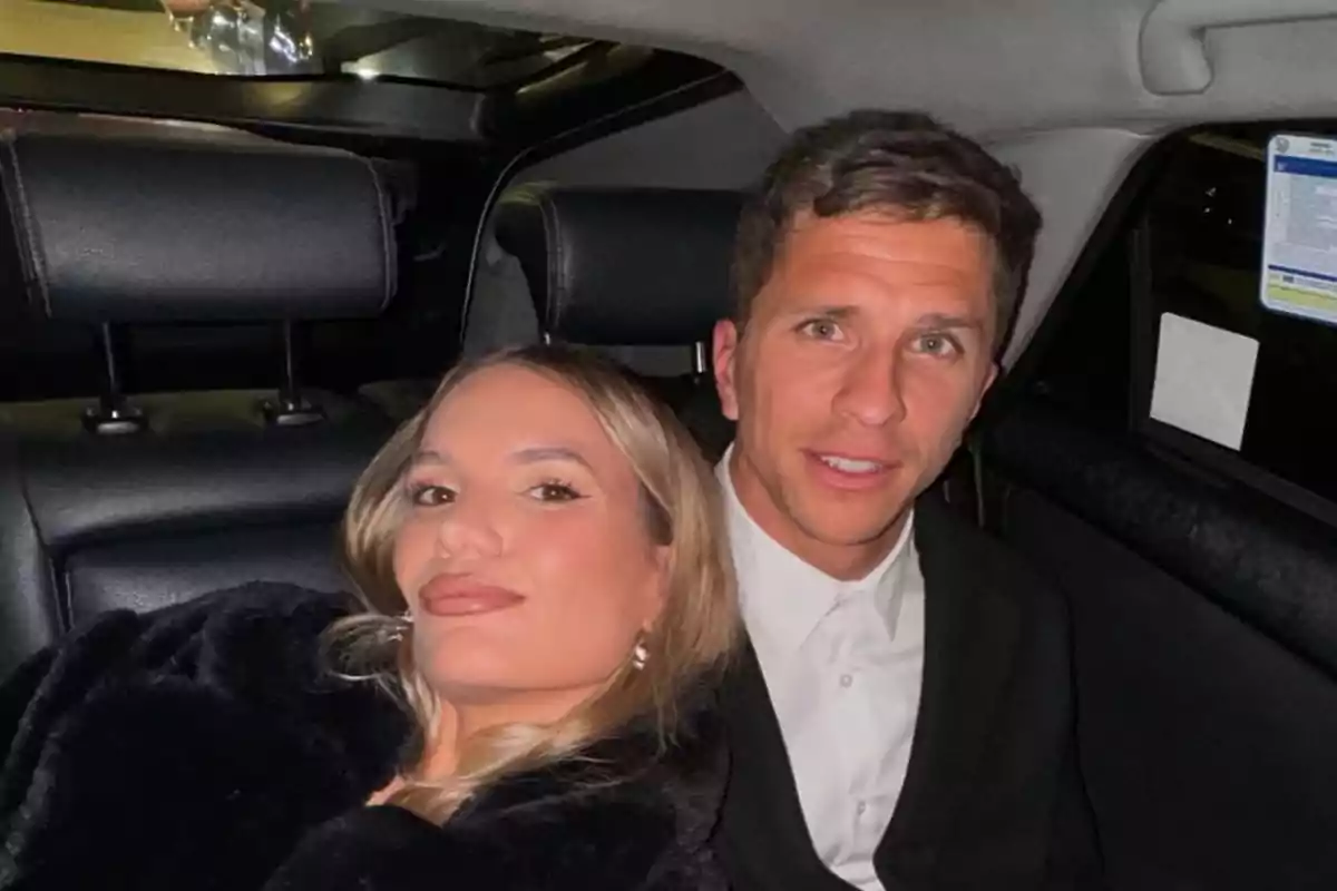 A couple sitting in the back seat of a car, both looking stylish and smiling at the camera. A couple sitting in the back seat of a car, both looking stylish and smiling at the camera.