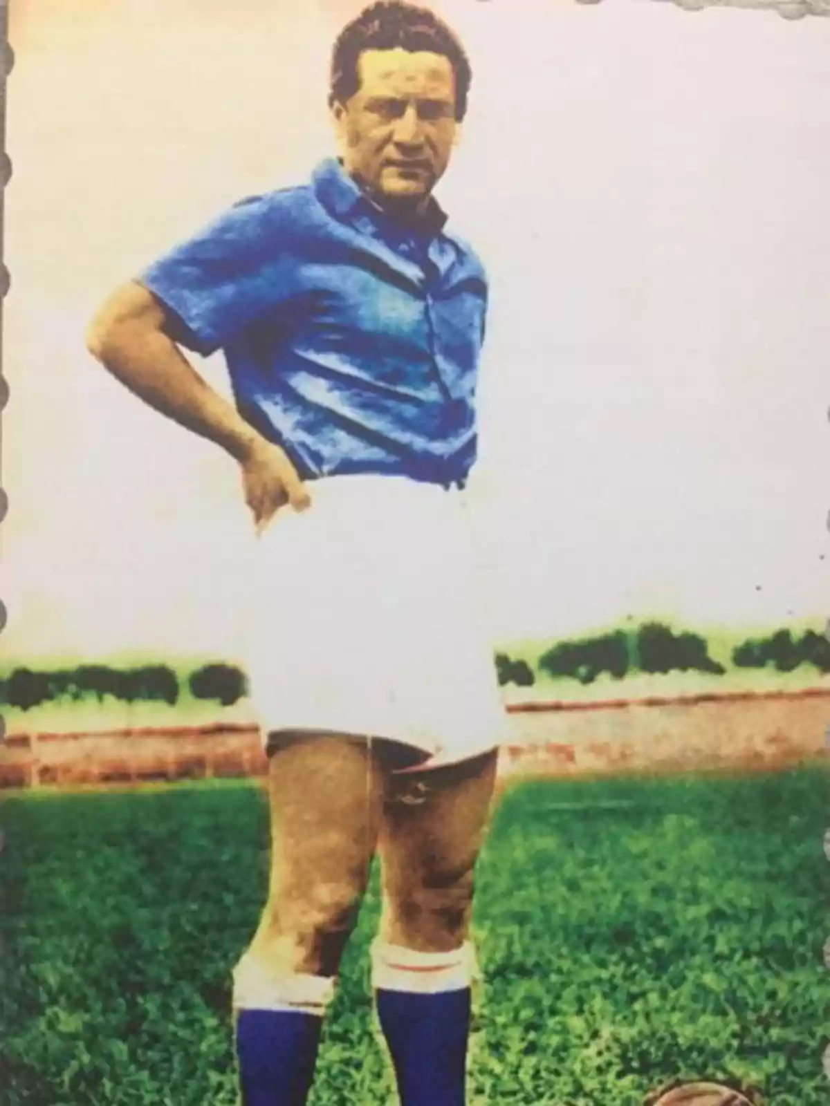 Un hombre de pie en un campo de fútbol con uniforme azul y blanco. Un hombre de pie en un campo de fútbol con uniforme azul y blanco.