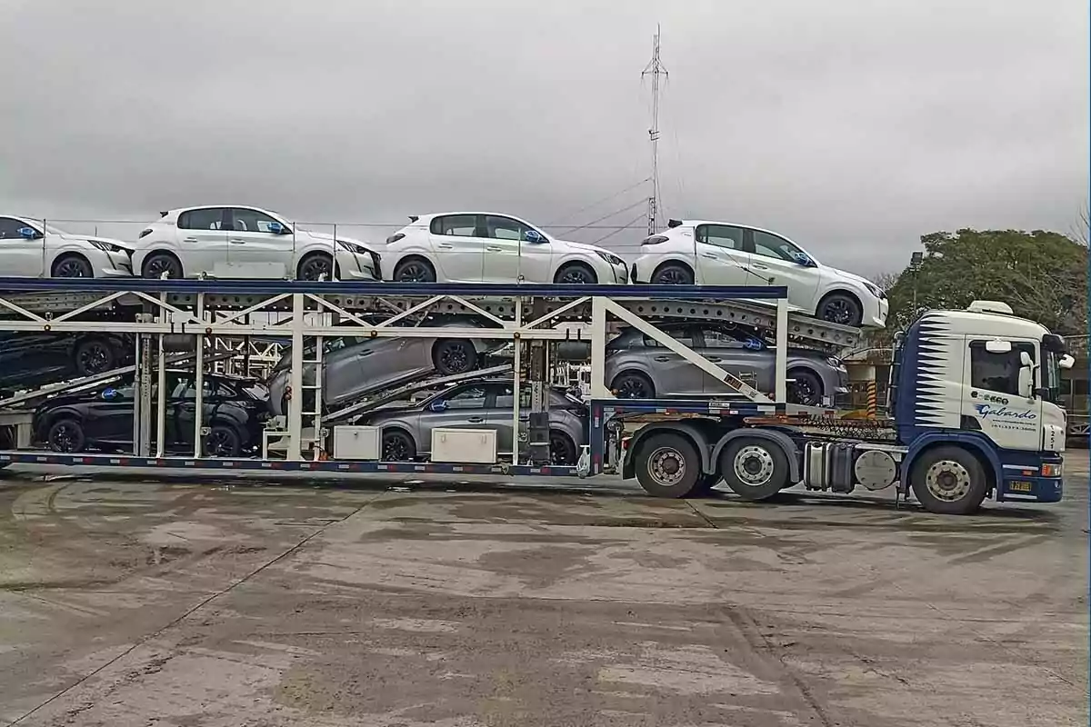 New car carrier truck in a parking lot under a cloudy sky New car carrier truck in a parking lot under a cloudy sky