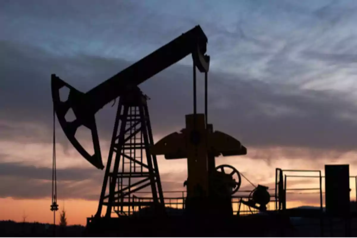 An oil pumpjack silhouetted against a sunset sky. An oil pumpjack silhouetted against a sunset sky.