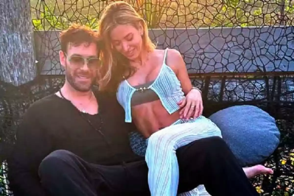 Una pareja sentada en un columpio al aire libre disfrutando de un momento juntos. Una pareja sentada en un columpio al aire libre disfrutando de un momento juntos.