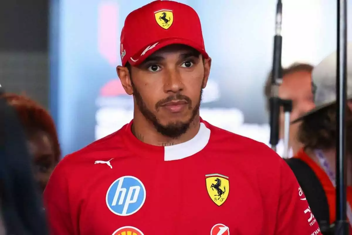 Hombre con gorra y camiseta rojas de Ferrari en un entorno interior Hombre con gorra y camiseta rojas de Ferrari en un entorno interior