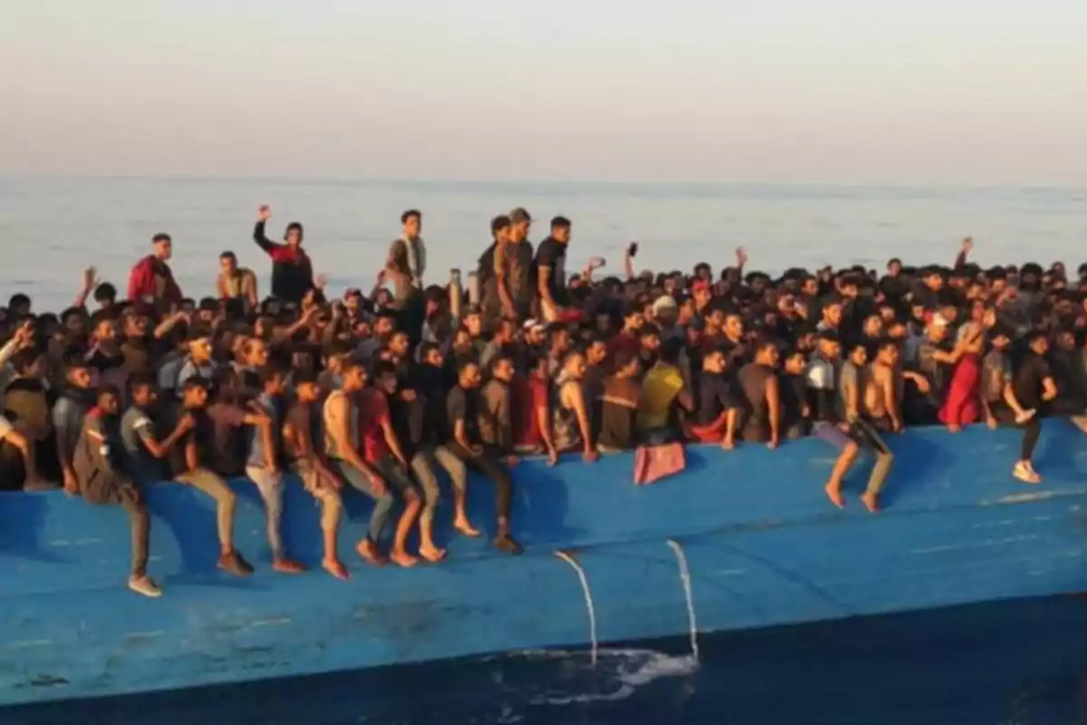 Un barco sobrecargado de personas en el mar.