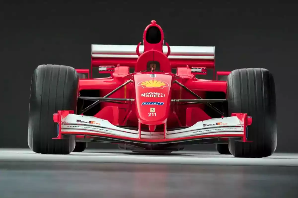 Red Formula 1 car seen from the front with wide tires and a white front wing Red Formula 1 car seen from the front with wide tires and a white front wing