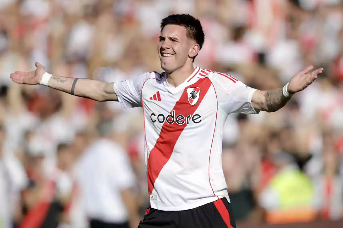 A player in a white and red uniform extends his arms in a stadium full of spectators.