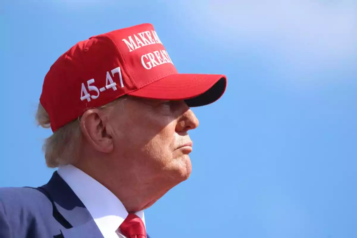 Hombre de perfil con gorra roja que tiene texto blanco sobre un fondo azul claro.