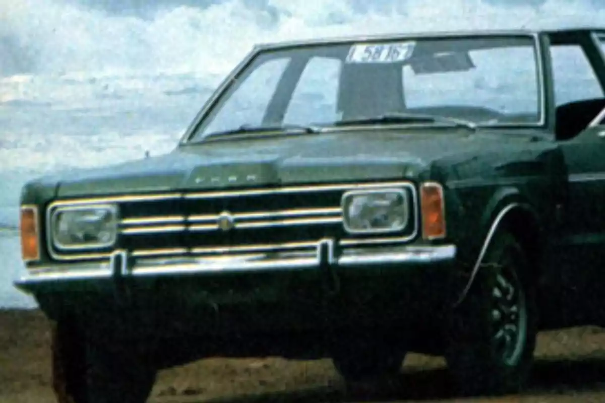 A dark green classic car parked near the beach with the ocean in the background. A dark green classic car parked near the beach with the ocean in the background.