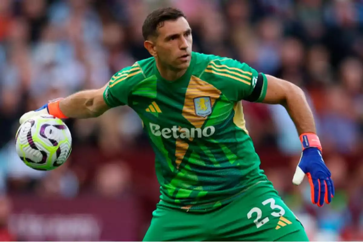 A player in a green uniform and blue gloves holds a ball in a stadium.