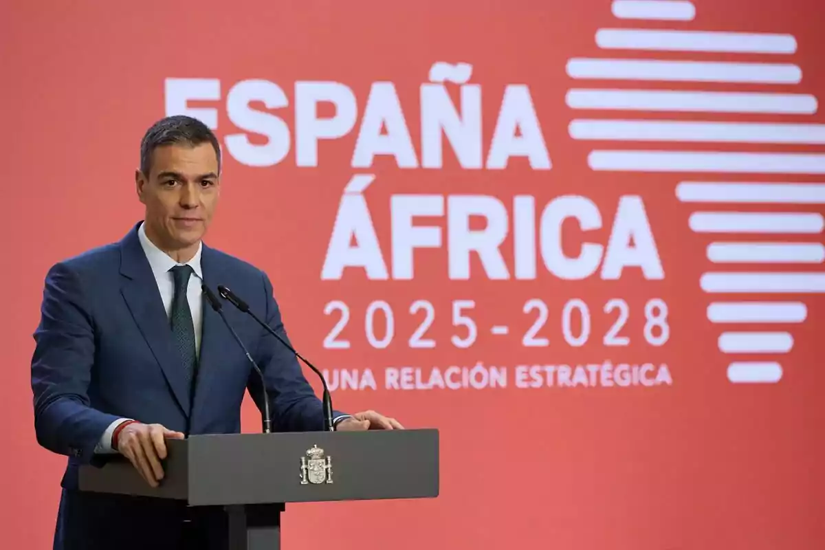 Un hombre en un podio con un fondo rojo que dice "España África 2025-2028 Una relación estratégica".