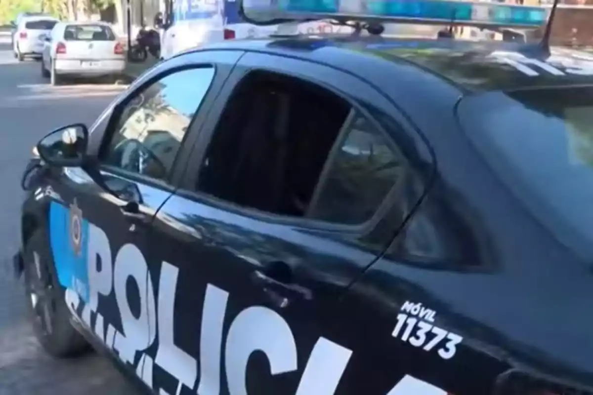 Un coche de policía estacionado en una calle con otros vehículos al fondo. Un coche de policía estacionado en una calle con otros vehículos al fondo.