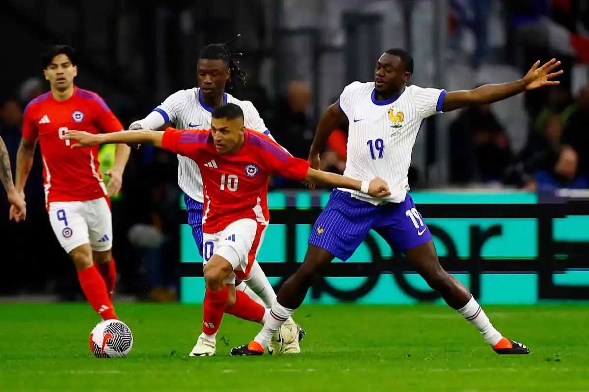 Jugadores de las selecciones de fútbol de Chile y Francia disputan el balón durante un partido Jugadores de las selecciones de fútbol de Chile y Francia disputan el balón durante un partido