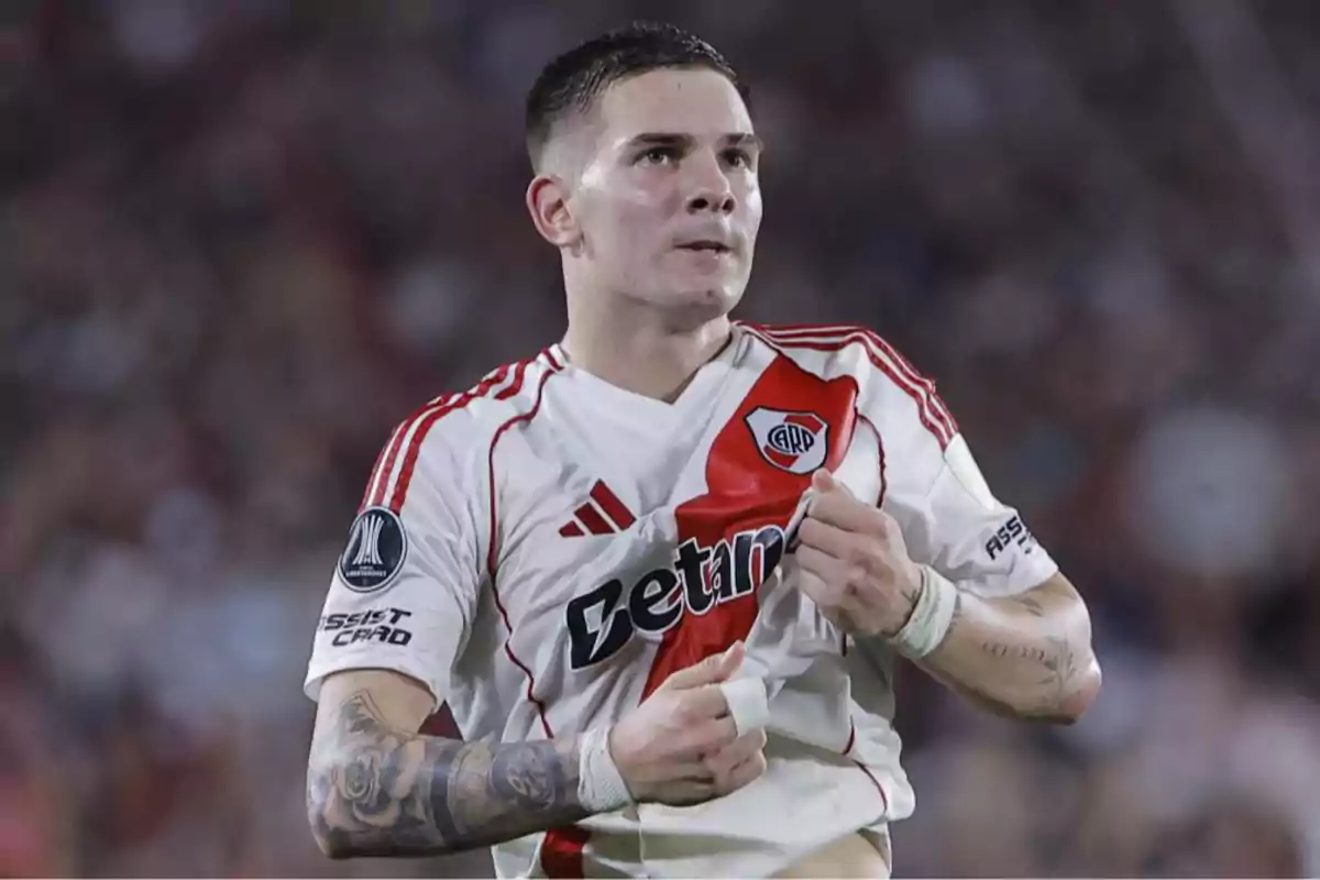 River Plate player celebrating a goal while holding the team jersey in a packed stadium River Plate player celebrating a goal while holding the team jersey in a packed stadium