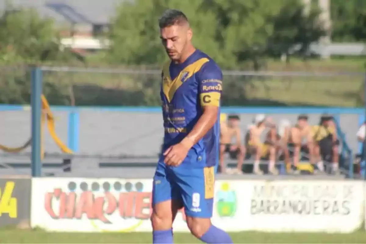 Soccer player in a blue and yellow uniform walking on the field during a match Soccer player in a blue and yellow uniform walking on the field during a match