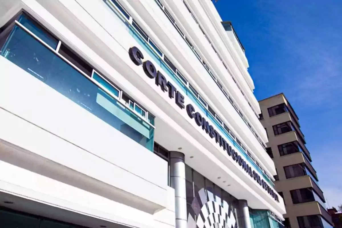 Modern building with a sign that says "Constitutional Court of Ecuador" under a blue sky.