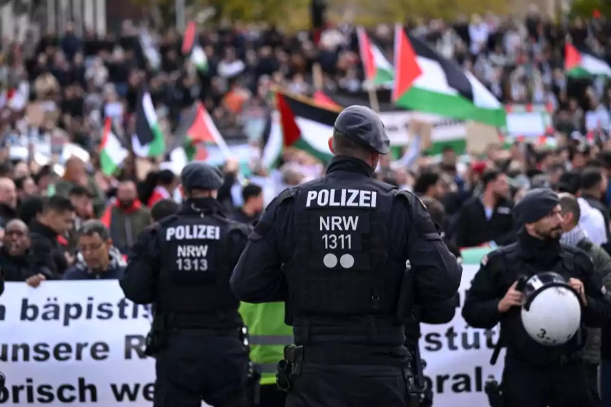 Police watch a crowd with flags at a demonstration. Police watch a crowd with flags at a demonstration.