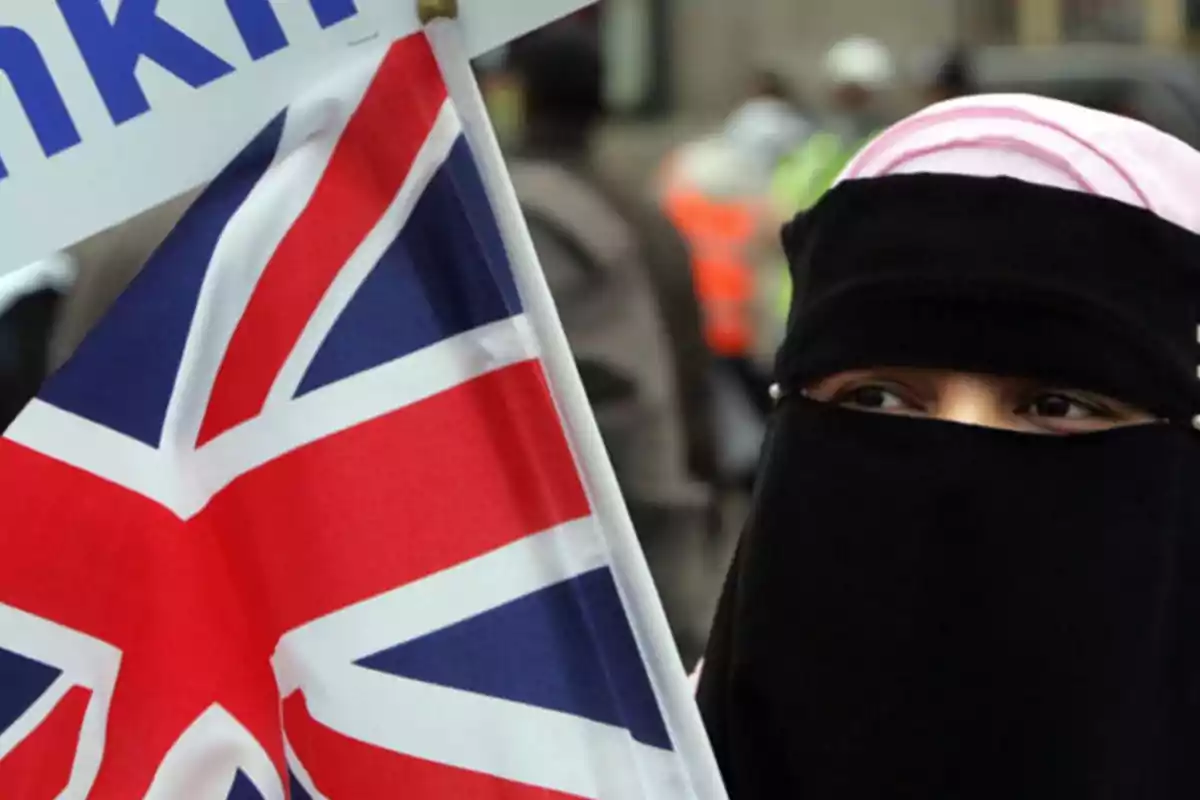 Persona con niqab sosteniendo una bandera del Reino Unido.