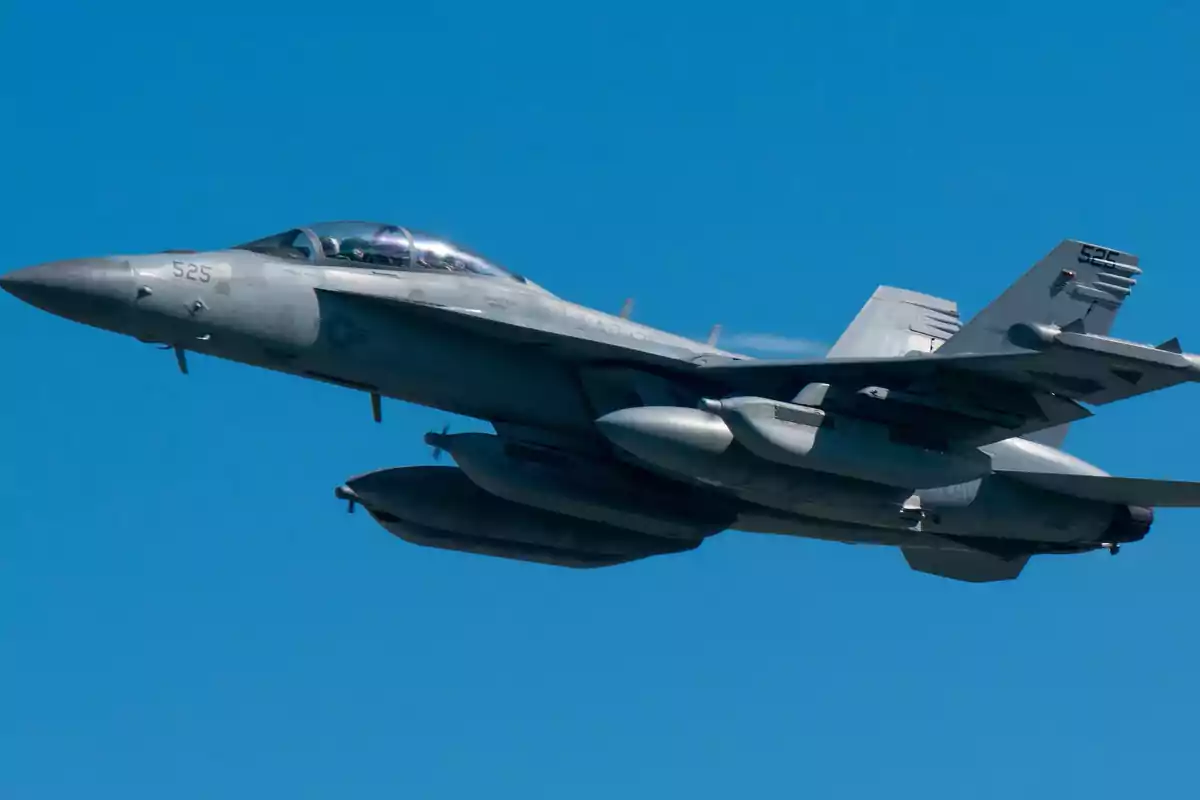 Un avión de combate volando en el cielo azul.