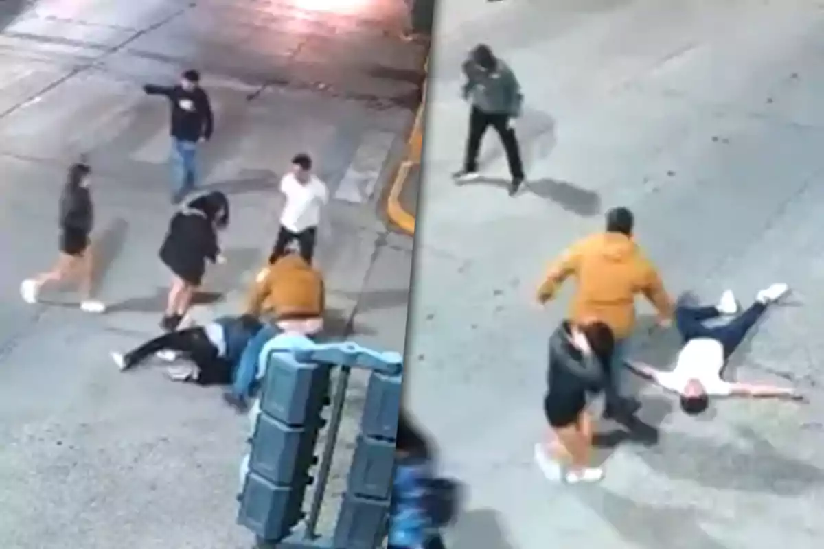 A group of people is involved in an altercation on the street, with some individuals on the ground and others standing around.