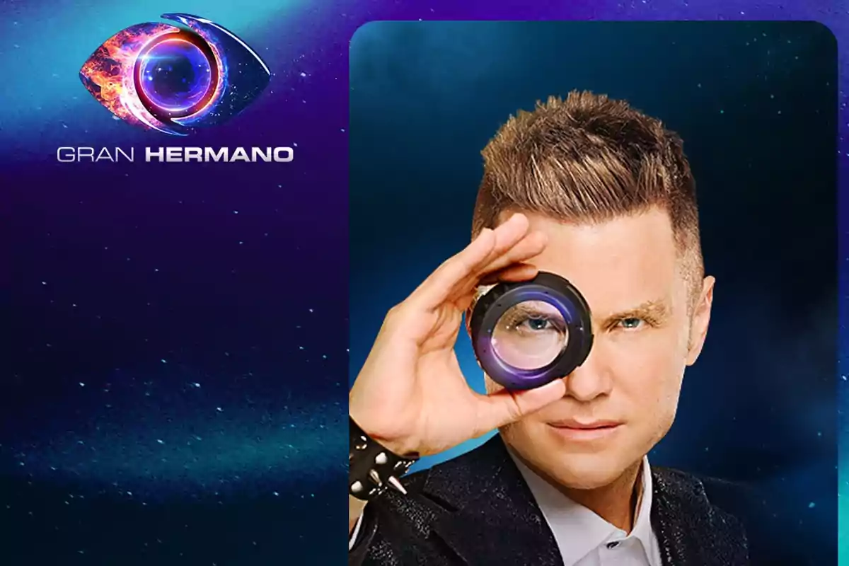 Hombre rubio con saco oscuro mirando a través de un lente frente a un fondo azul con el logo de Gran Hermano a la izquierda