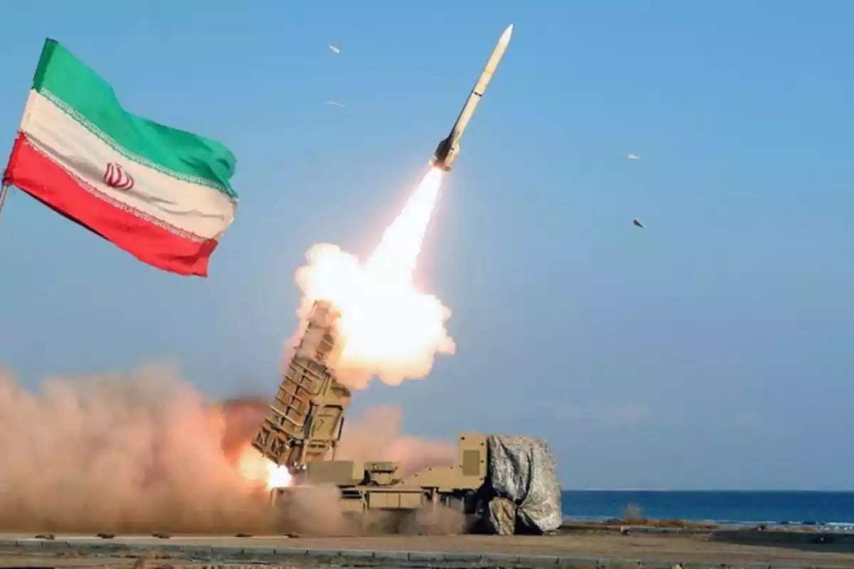 Un misil es lanzado desde una plataforma militar cerca del mar mientras una bandera de Irán ondea en primer plano