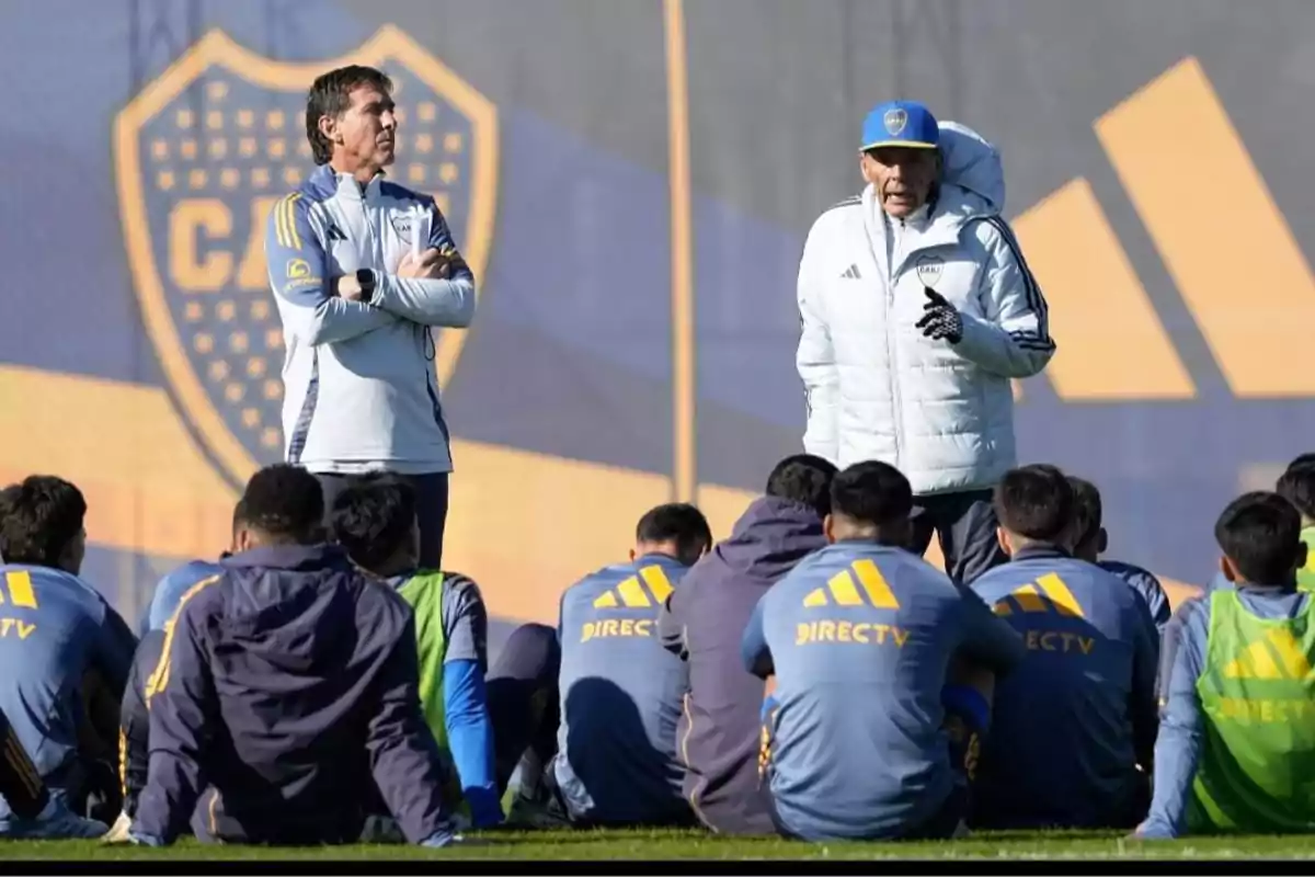 Entrenadores de fútbol hablando con un grupo de jugadores sentados en el campo de entrenamiento del club Boca Juniors Entrenadores de fútbol hablando con un grupo de jugadores sentados en el campo de entrenamiento del club Boca Juniors