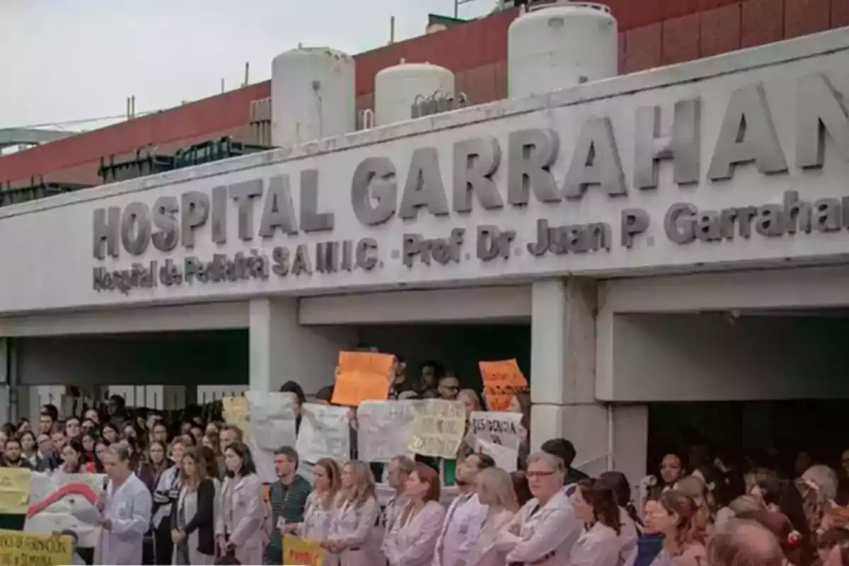 Facade of the Garrahan Hospital with a group of people gathered holding signs and banners