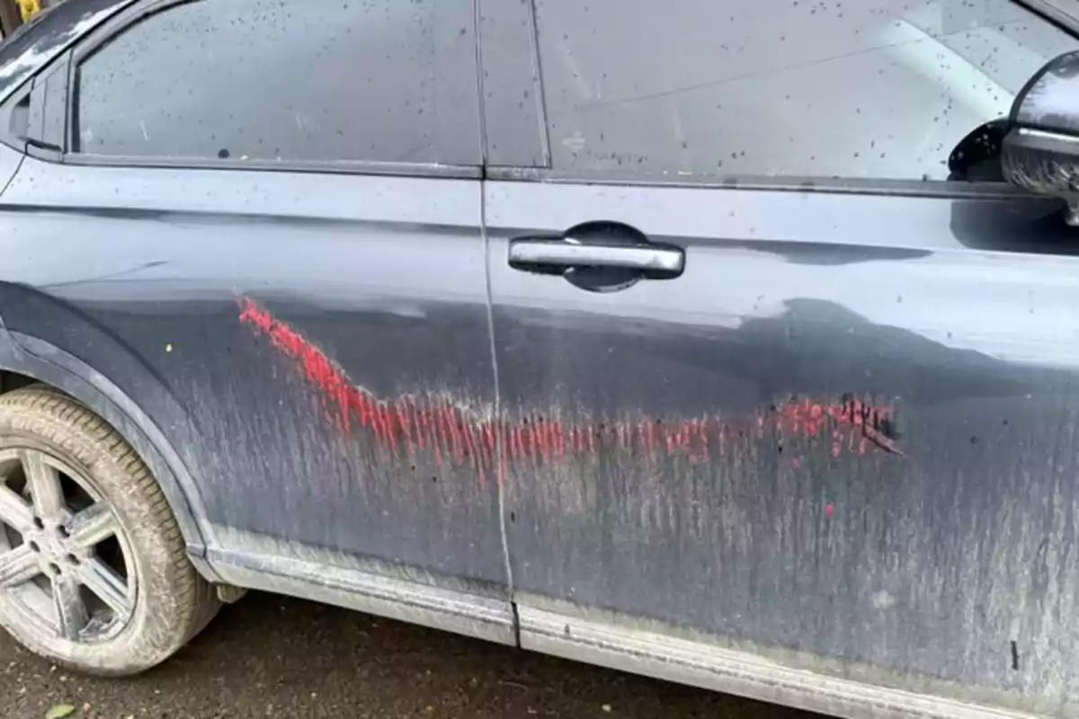 Black car door with a big red stripe and dirt on the lower part Black car door with a big red stripe and dirt on the lower part