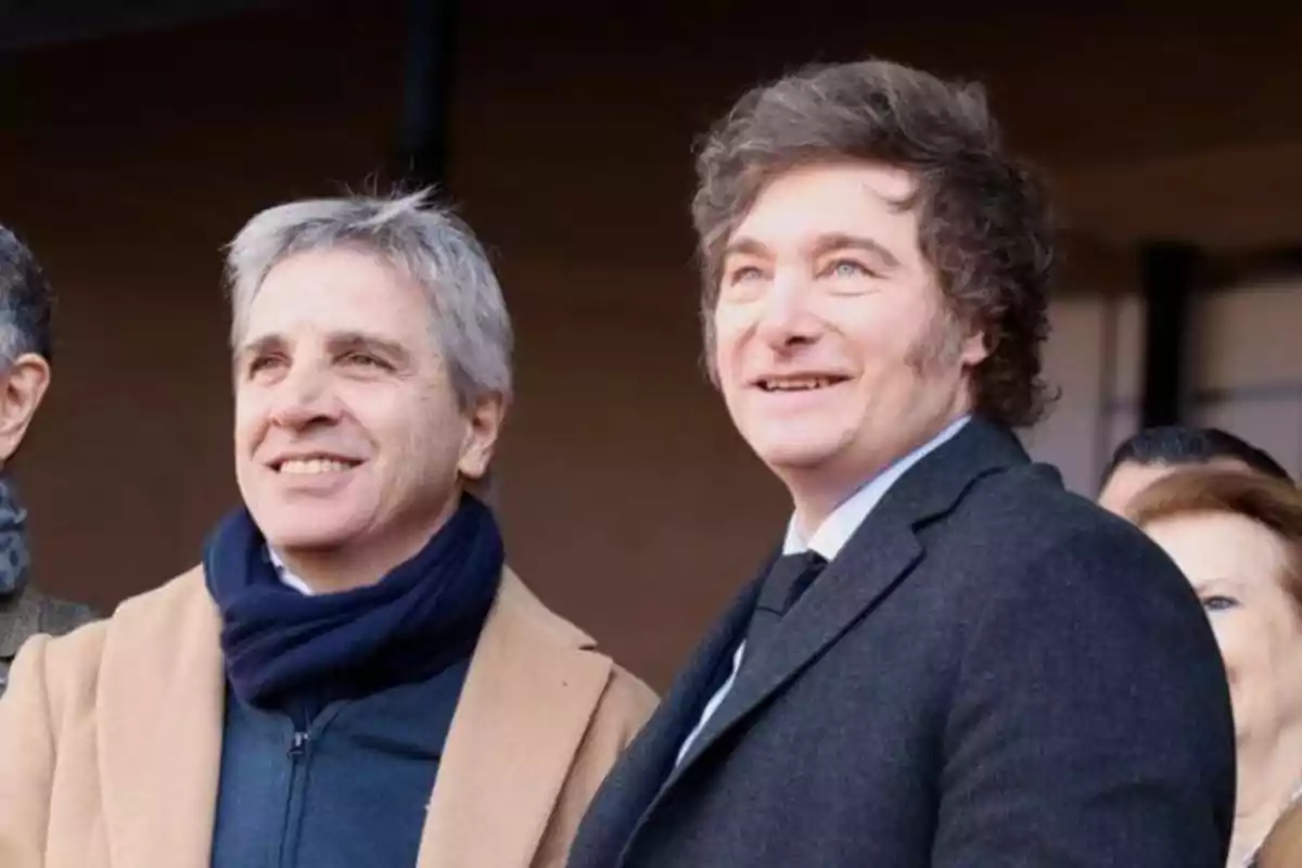 Dos hombres sonrientes posando juntos en un evento al aire libre.