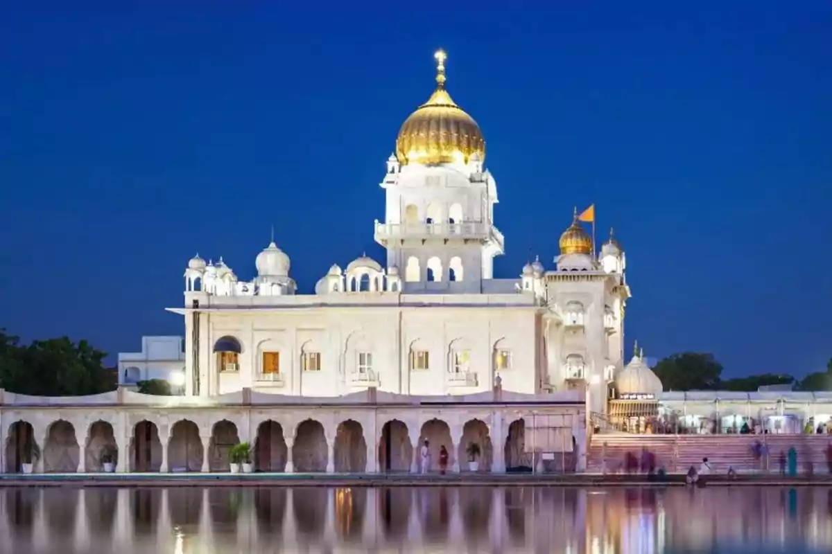 A temple with golden domes reflected in the water during sunset. A temple with golden domes reflected in the water during sunset.