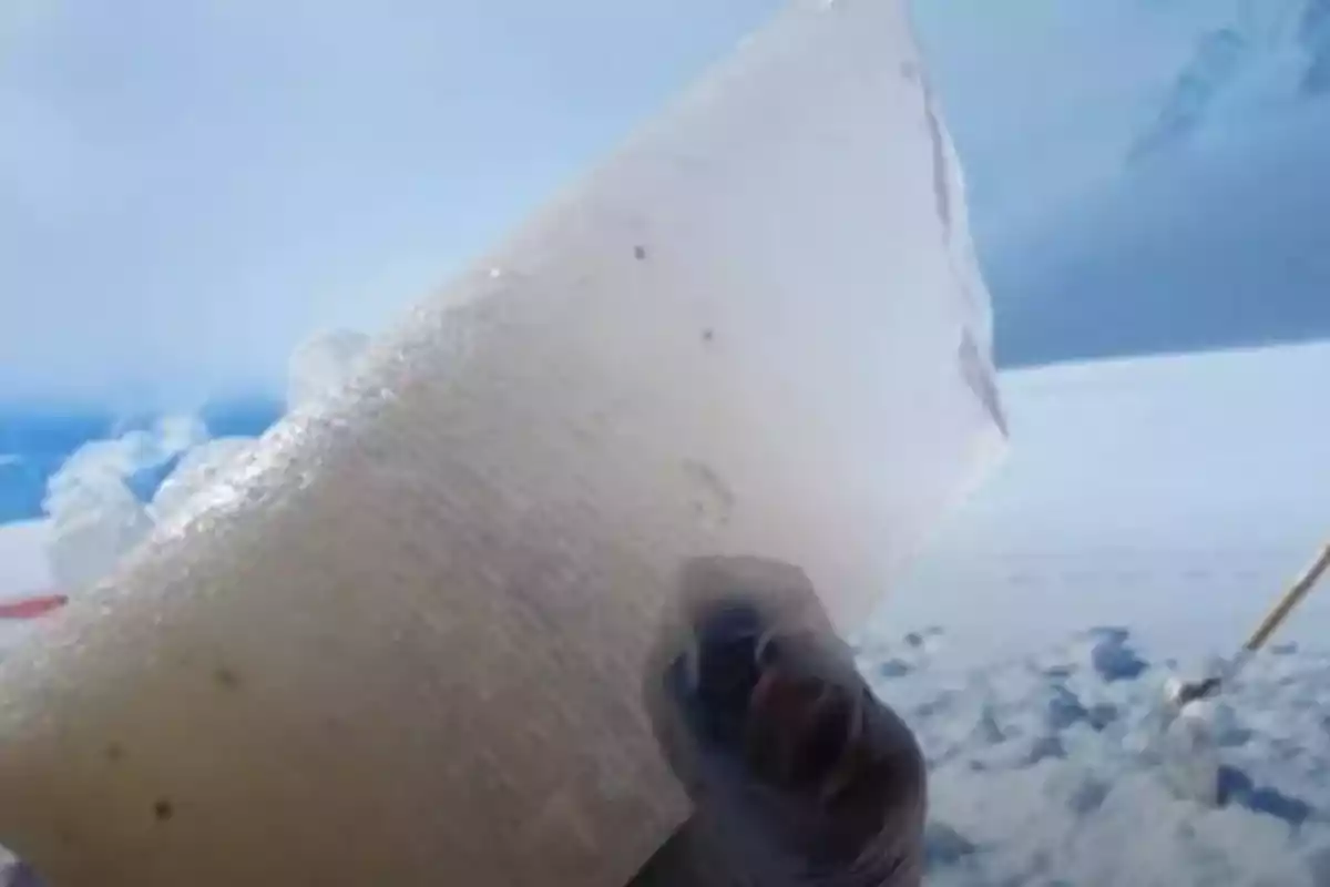 Person holding a transparent block of ice in a snowy landscape Person holding a transparent block of ice in a snowy landscape