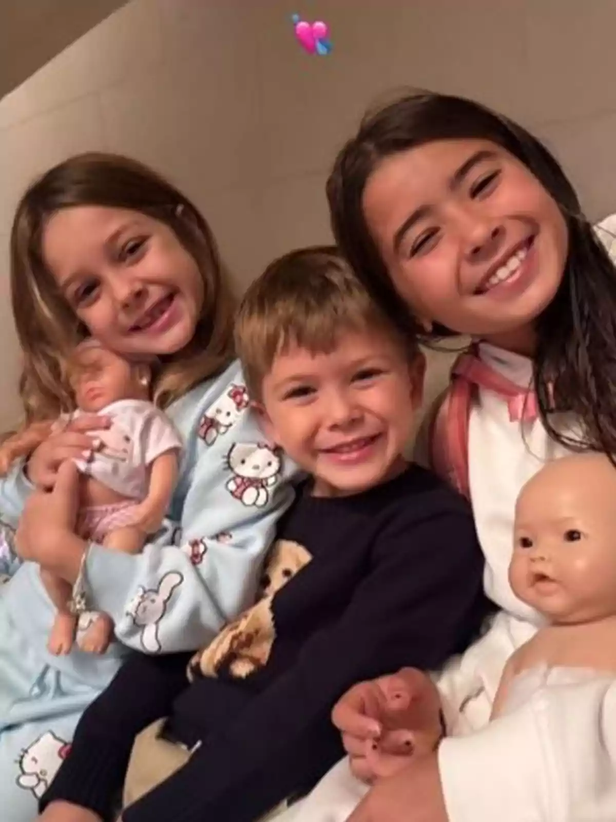 Tres niños sonríen mientras sostienen muñecos, mostrando felicidad y camaradería. Tres niños sonríen mientras sostienen muñecos, mostrando felicidad y camaradería.
