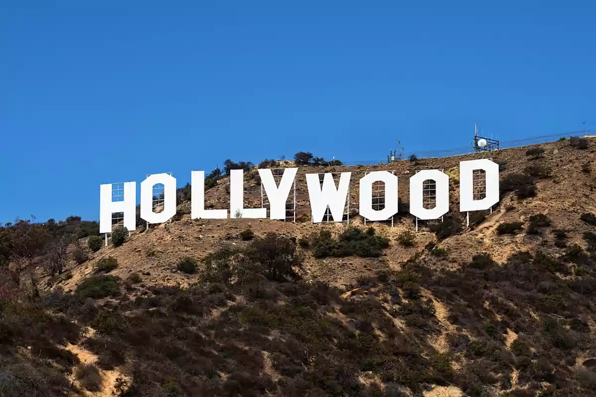 Letrero icónico de Hollywood en una colina bajo un cielo azul. Letrero icónico de Hollywood en una colina bajo un cielo azul.