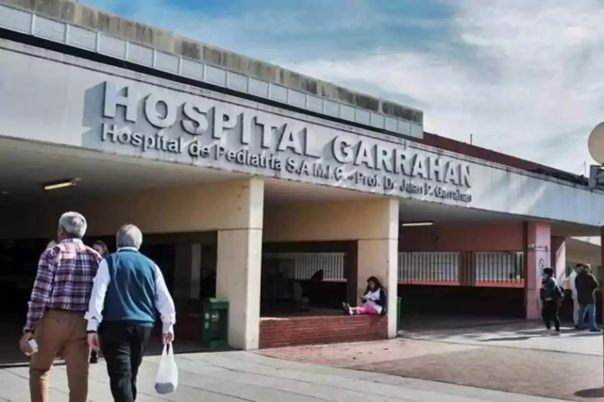 Fachada del Hospital Garrahan con personas entrando y saliendo del edificio en un día soleado