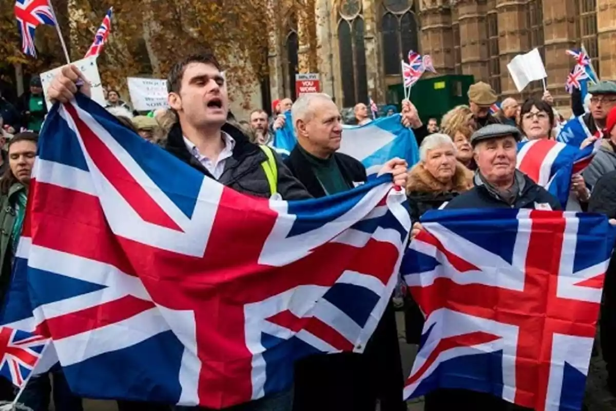 People holding United Kingdom flags at a protest. People holding United Kingdom flags at a protest.