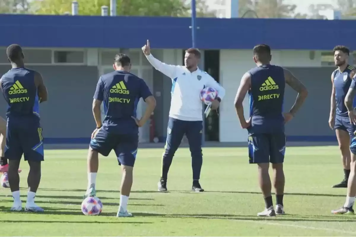 Un grupo de jugadores de fútbol escucha atentamente a su entrenador en el campo de entrenamiento. Un grupo de jugadores de fútbol escucha atentamente a su entrenador en el campo de entrenamiento.