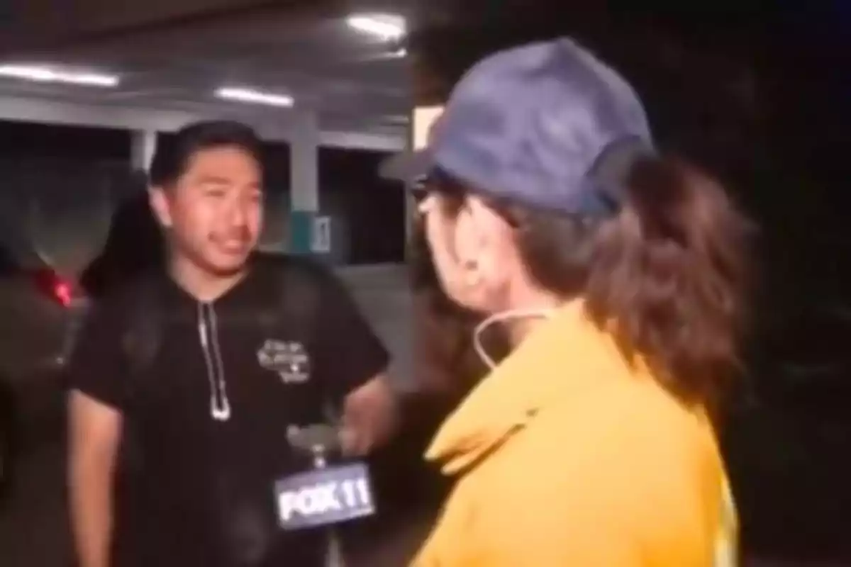 Una reportera entrevista a un hombre en un estacionamiento mientras sostiene un micrófono de Fox 11.