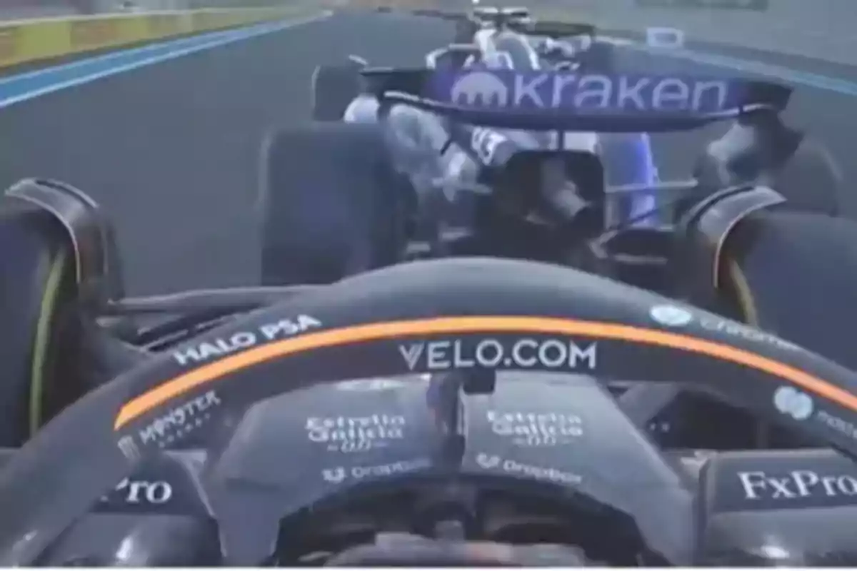 Two Formula 1 cars on a track, one behind the other, with visible logos on the wings. Two Formula 1 cars on a track, one behind the other, with visible logos on the wings.