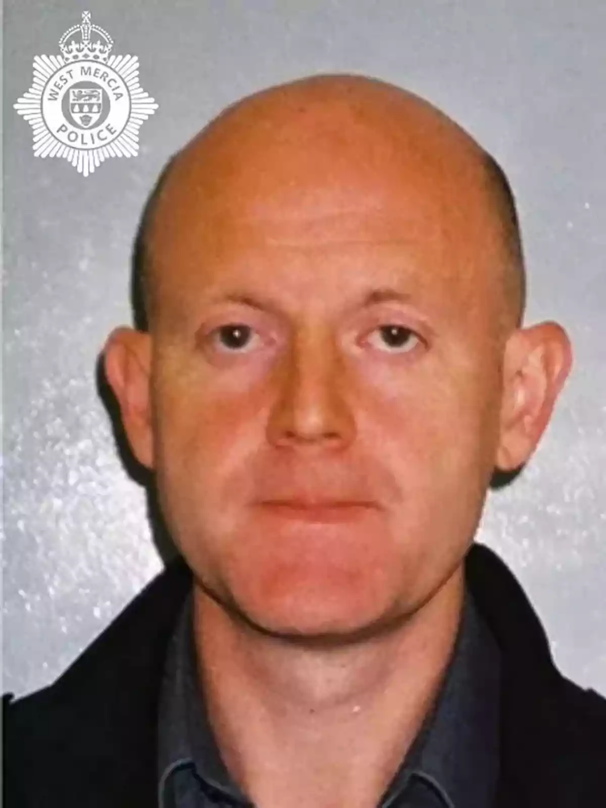 A bald man in a dark jacket in front of a gray background with the West Mercia Police logo in the top left corner. A bald man in a dark jacket in front of a gray background with the West Mercia Police logo in the top left corner.