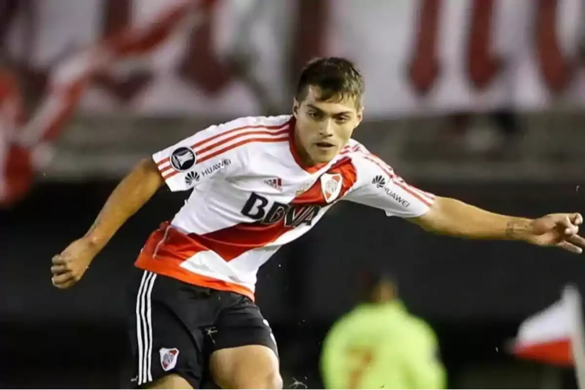 Jugador de fútbol con uniforme de River Plate en acción durante un partido. Jugador de fútbol con uniforme de River Plate en acción durante un partido.