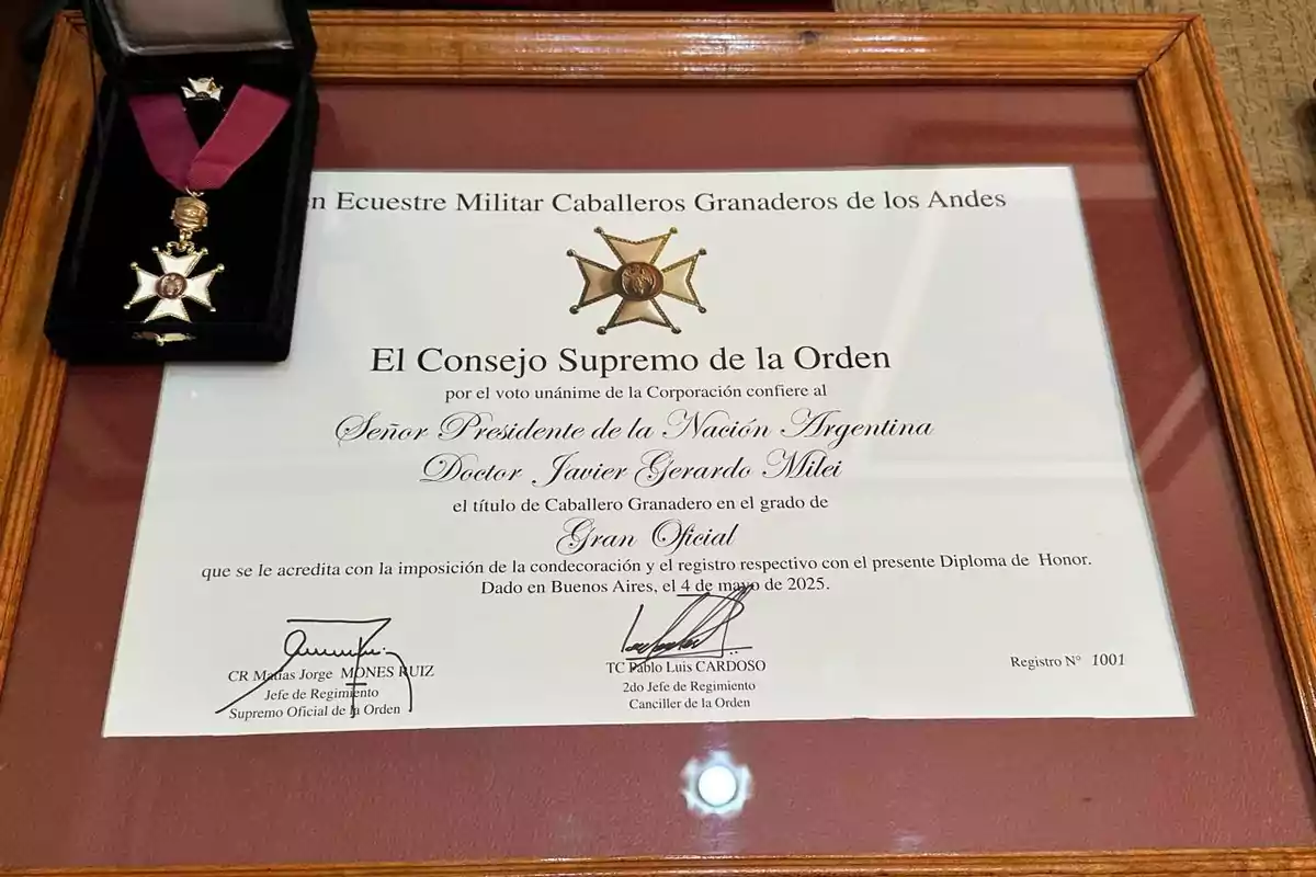 Una placa enmarcada con un diploma de honor y una medalla en una caja negra, otorgada por el Consejo Supremo de la Orden Ecuestre Militar Caballeros Granaderos de los Andes al Presidente de la Nación Argentina, con firmas y detalles de la condecoración. Una placa enmarcada con un diploma de honor y una medalla en una caja negra, otorgada por el Consejo Supremo de la Orden Ecuestre Militar Caballeros Granaderos de los Andes al Presidente de la Nación Argentina, con firmas y detalles de la condecoración.