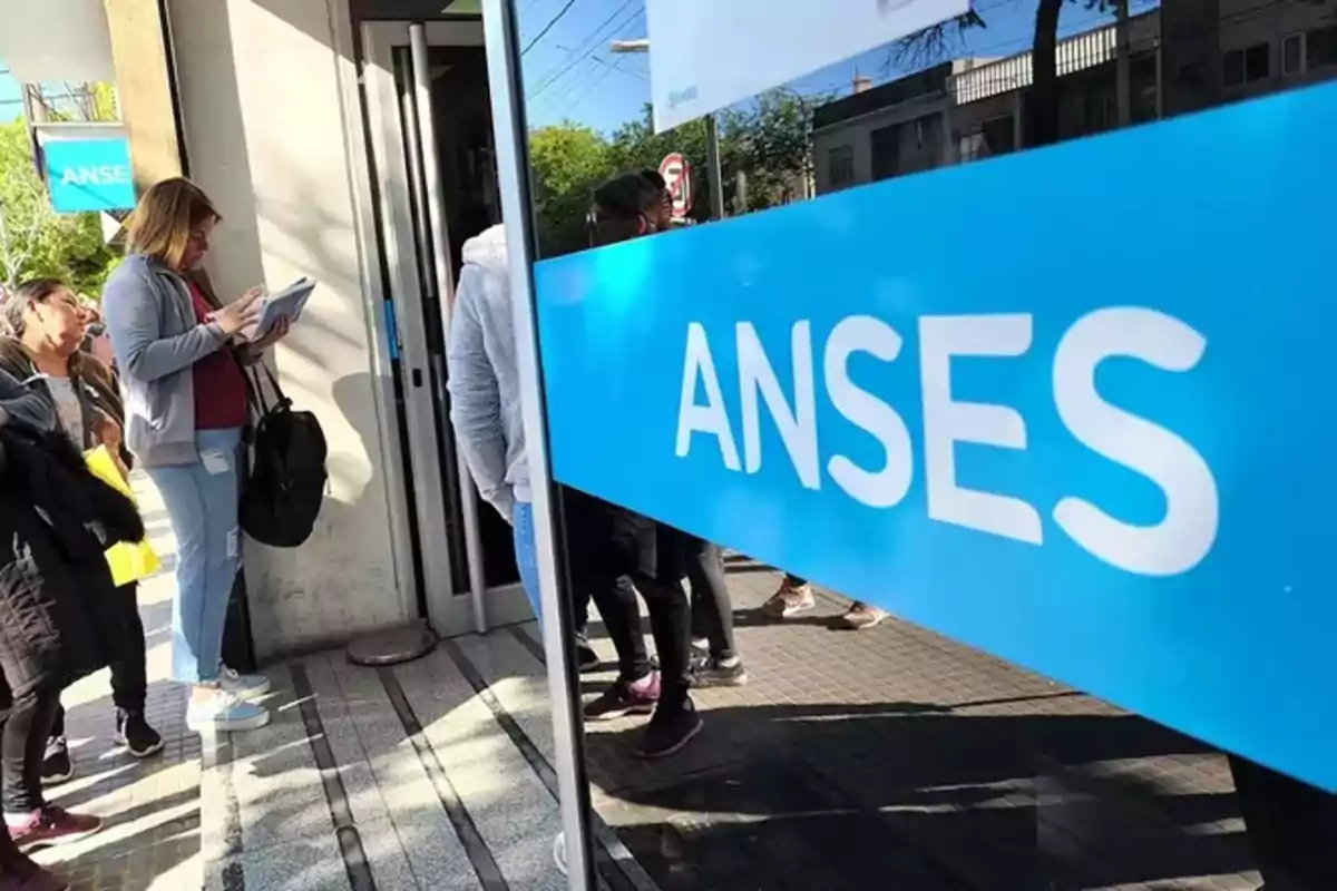 Personas haciendo fila en la entrada de una oficina de ANSES.