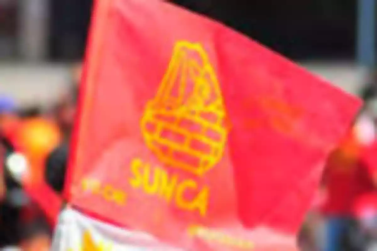 Red flag with the yellow SUNCA union logo waving at a demonstration Red flag with the yellow SUNCA union logo waving at a demonstration