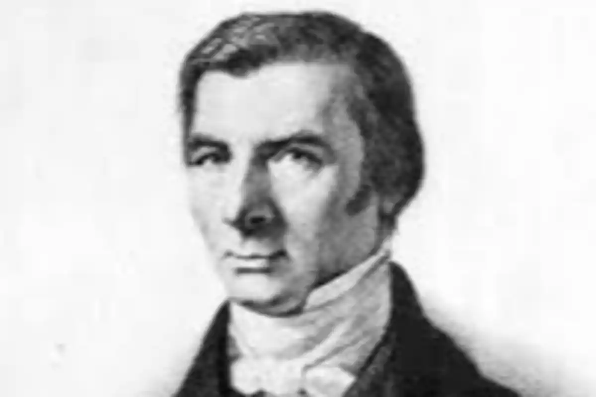 Retrato en blanco y negro de un hombre con cabello corto y patillas vistiendo chaqueta oscura y pañuelo blanco Retrato en blanco y negro de un hombre con cabello corto y patillas vistiendo chaqueta oscura y pañuelo blanco