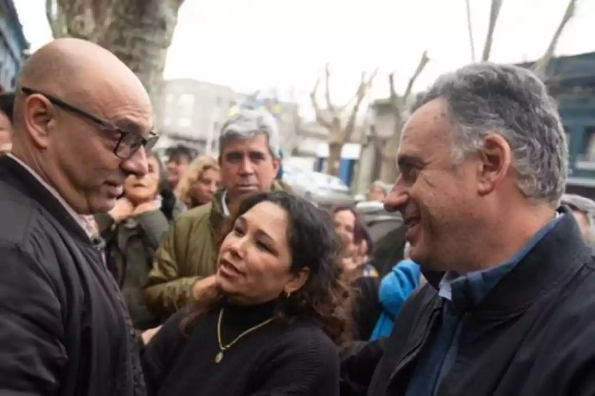 Un grupo de personas conversando al aire libre en un entorno urbano.